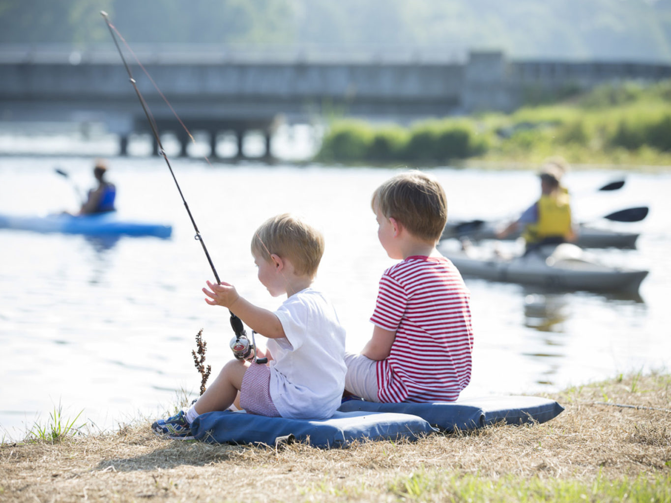 Kids fishing in Lake Blackshear while a family kayaks by the SAM Trainline